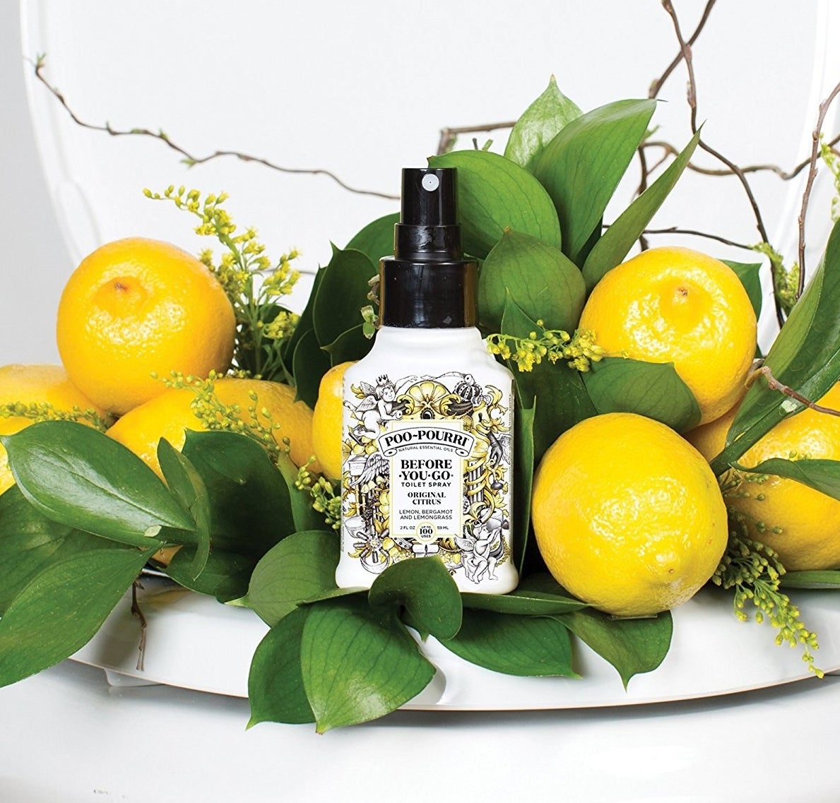 the bottle of poo-pourri displayed next to some lemons