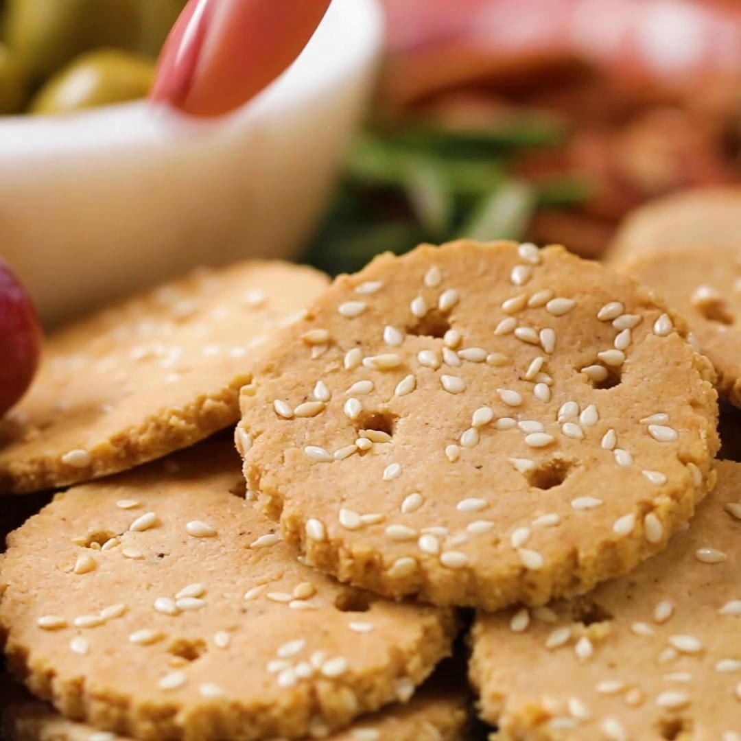 Servings: 4 INGREDIENTS2 cups almond flour1 teaspoon salt½ teaspoon pepper1 tablespoon sesame seeds, plus more for sprinkling2 tablespoons avocado oil or olive oil3-5 tablespoons ice waterPREPARATION1.Preheat the oven to 350˚F (180˚C). 2.Combine the almond flour, salt, pepper, and sesame seeds in a large bowl. 3.Add the avocado oil and mix thoroughly with a fork. 4.Add the ice water, 1 tablespoon at a time, and mix thoroughly, until small clumps form and the dough holds together when squeezed.5.Form the dough into a round, flattening the top and bottom as evenly as possible. 6.Place the dough on a sheet of parchment paper and add another piece of parchment on top. Roll out the dough as evenly as possible, to between ¼- and ⅛-inch thick.7.Remove the top layer of parchment paper and place on a baking sheet. You may need to press the edges of the dough to form an even rectangle.8.Using a cookie cutter or pizza cutter, slice the dough to desired size. If using a cookie cutter, re-roll the excess dough and cut out more crackers. If desired, use the blunt end of a skewer to poke holes in each of the crackers. 9.Carefully place the crackers on the baking sheet. If the dough is too warm, the crackers will break as you attempt to transfer them. Chill in the freezer for 10 minutes before proceeding if this happens.10.Bake for 15-20 minutes, flipping halfway, until golden brown. 11.Let the crackers cool completely and serve as desired. Store up to 1 week at room temperature in an airtight container. 12.Enjoy!