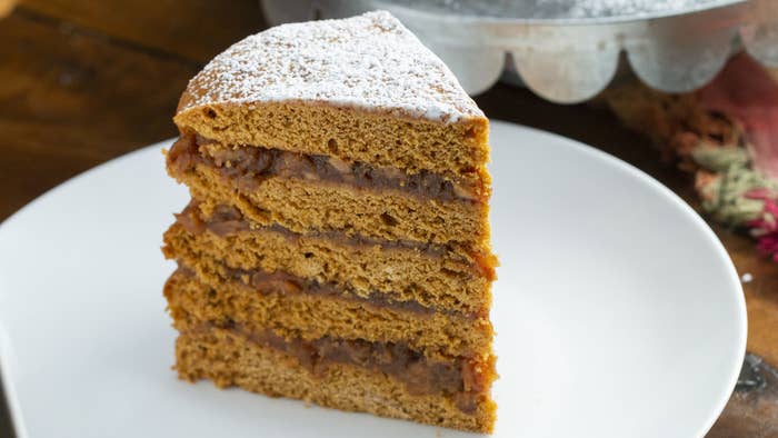 Servings: 12INGREDIENTS Apple Filling:1 pound dried apples 1 cup brown sugar1 teaspoon ground cinnamon1 teaspoon ground ginger½ teaspoon ground nutmeg4 cups waterCake:5 cups all-purpose flour, plus more for dusting1 teaspoon baking powder1 teaspoon baking soda1 teaspoon salt1 teaspoon cinnamon¾ cup (1½ sticks) unsalted butter, room temperature1 cup granulated sugar2 large eggs1 cup molasses1 cup buttermilk Powdered sugar, for servingPREPARATION1. Make the apple filling: Combine the dried apples, brown sugar, cinnamon, ginger, nutmeg, and water in a large pot over medium-high heat. Bring to a light boil, then reduce the heat to low. Cook for 30 minutes-1 hour, or until the apples are tender and have absorbed the liquid.2. Mash the apples with a potato masher until no large chunks remain. Remove from the heat and let cool.3. Make the cake: In a large bowl, combine the flour, baking powder, baking soda, salt, and cinnamon.4. In a separate large bowl, cream together the butter and sugar until light and fluffy.5. Add the eggs and molasses, and whisk until fully incorporated and the mixture is light brown. 6. Add ⅓ of the flour mixture to the wet ingredients and fold with a spatula until fully incorporated. Add half of the buttermilk and stir until fully combined. Continue alternating with the remaining flour and buttermilk, fully incorporating each addition before adding the next. The batter will be thicker than a traditional cake batter.7. Chill the cake batter for 30 minutes.8. Preheat the oven to 350˚F (180˚C). Grease as many 9-inch cake pans as you have and line with parchment paper.9. Dump the cake batter onto a floured surface and dust with more flour. Pat into a rectangle, then divide into 5 equal pieces.10. Transfer a piece of cake batter to a prepared pan and pat into an even layer. Bake for 12 minutes, until firm. Repeat with the remaining layers. Let cool completely.11. To assemble, add a cake layer to a serving plate and top with a layer of apple filling. Spread evenly. Repeat with the remaining cake layers and filling.12. Wrap the cake in plastic wrap and chill for 24 hours.13. Dust the cake with powdered sugar, then slice and serve.14. Enjoy!Inspo: http://www.kentuckymonthly.com/food/featured/appalachian-apple-stack-cake/ https://www.thekitchn.com/how-to-make-apple-stack-cake-240546 https://www.epicurious.com/recipes/food/views/apple-jack-stack-cake-56390148https://www.ourstate.com/appalachian-apple-stack-cake/