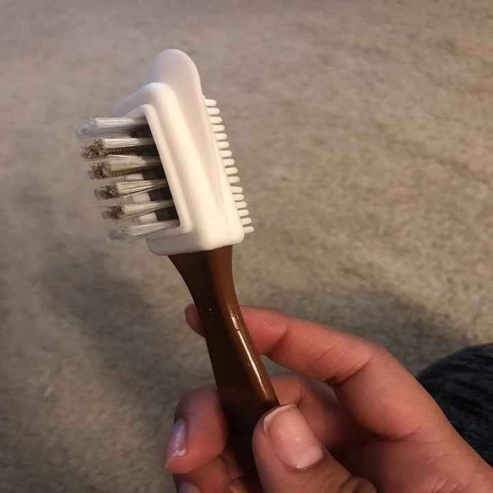 a hand holding the cleaning brush