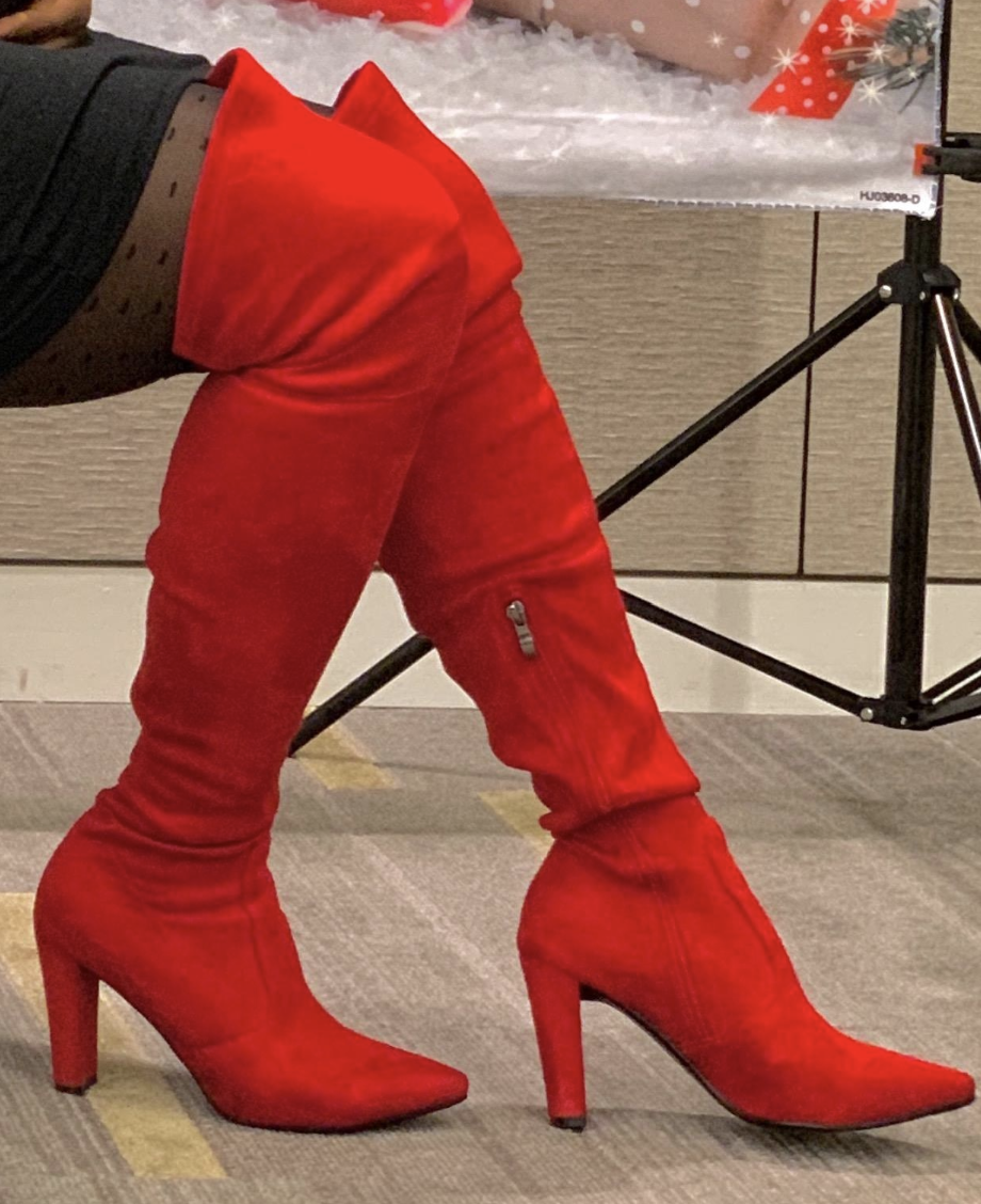 Reviewer wearing the thigh-high high heel pointed toe boots in bright red suede