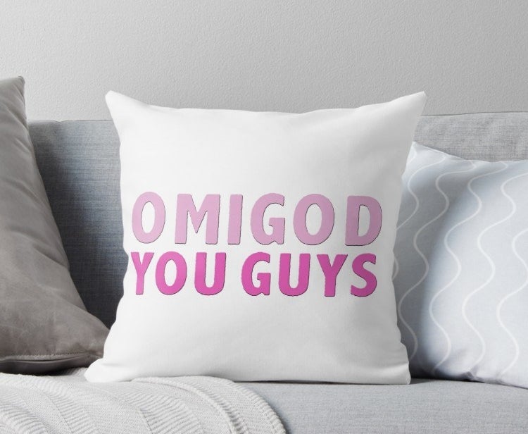 White square pillow with the words &quot;Omigod you guys&quot; written in pink on it