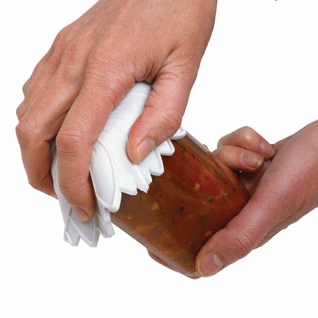 the rubber grip being used to open a jar of salsa