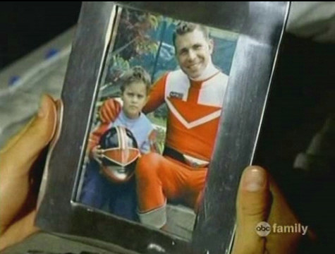 two hands hold a picture frame with a photo of a dad and son