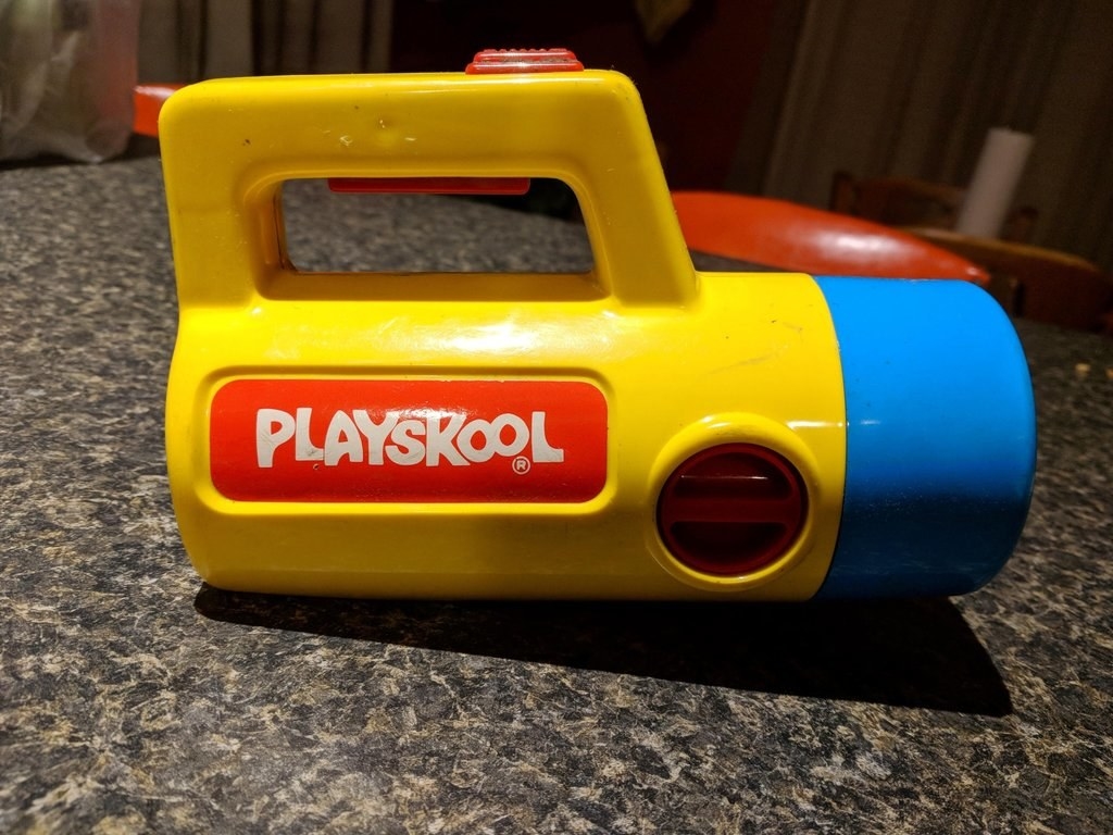 Close up shot of a yellow and blue Playskool flashlight