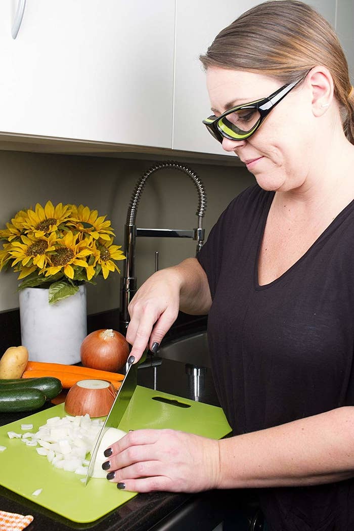 Model chopping onions while wearing onion goggles