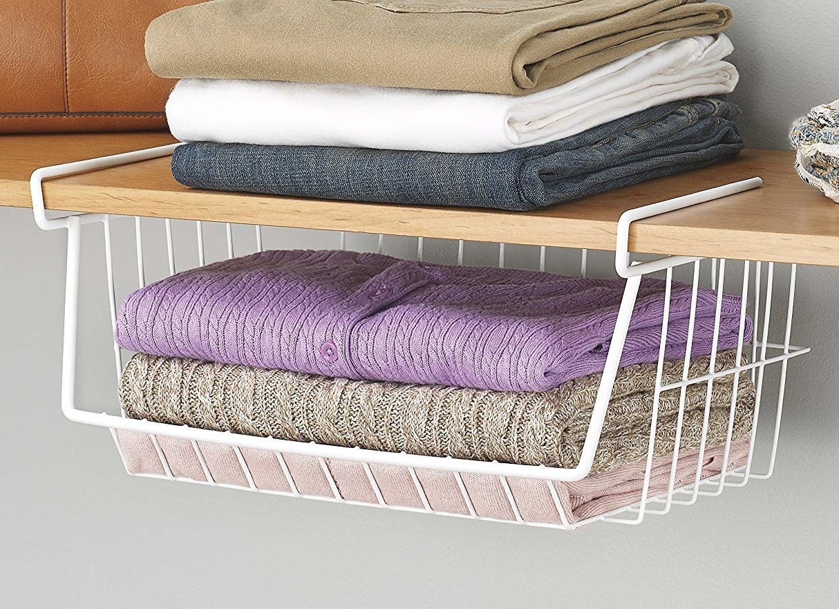 white wire basket with sweaters inside