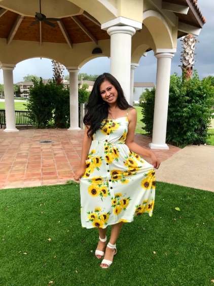 A reviewer wearing the dress in sunflower print