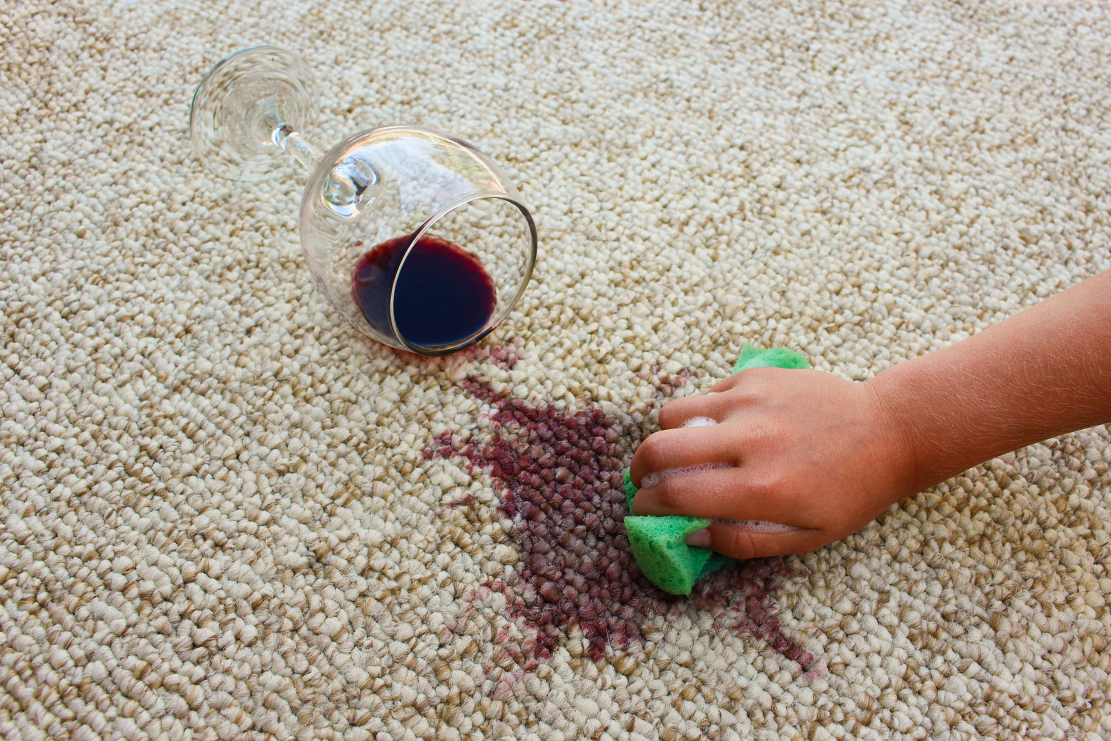 Red wine spilt on a white carpet