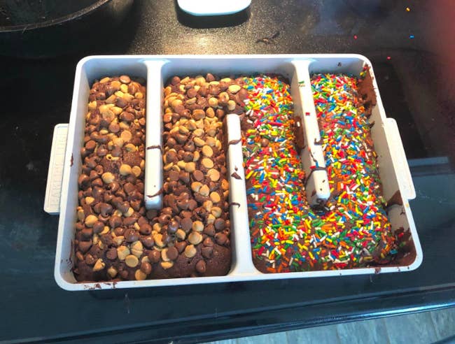 The pan, which has barriers in the middle that almost make it look like a maze shape. This reviewer has covered half the brownies with chocolate and peanut butter chips and the other half with sprinkles