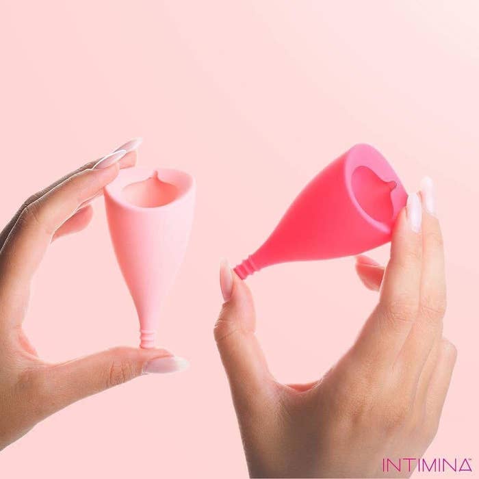 hands holding one light pink and one hot pink lily cup with an angled opening and textured stem