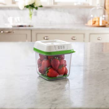 The rectangular plastic container with strawberries inside