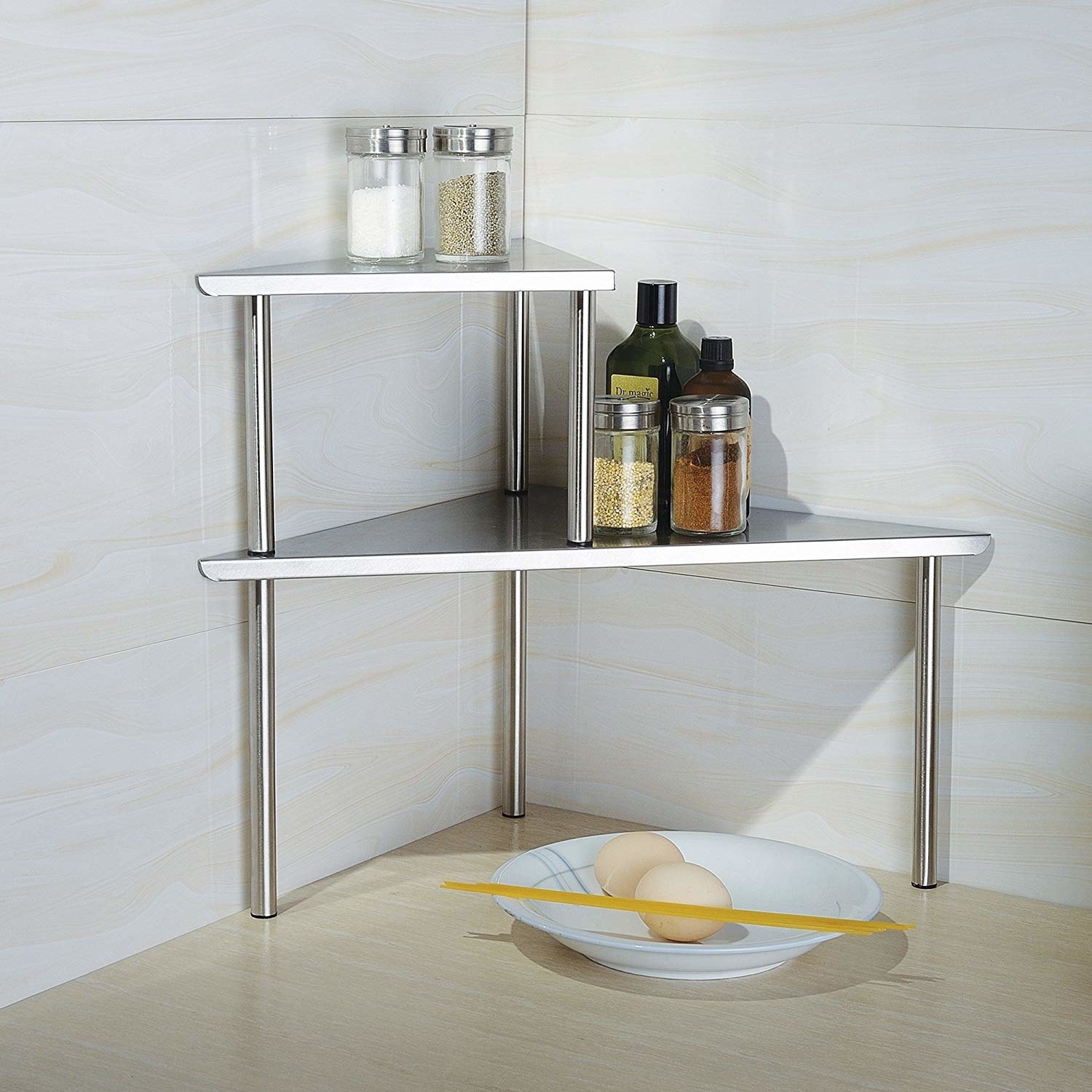 Two-tiered stainless-steel corner shelf with spices and oils displayed 