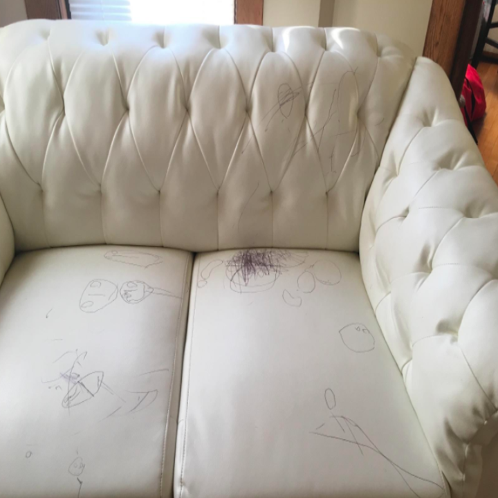 white leather couch with tons of pen scribbles on it