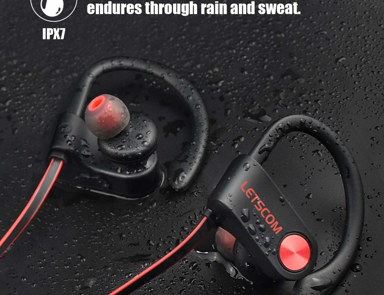 earbuds with over-ear pieces laying among droplets of water