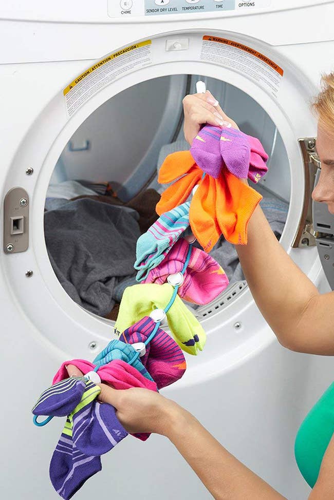 Socks being removed from dryer attached to a clip rod 