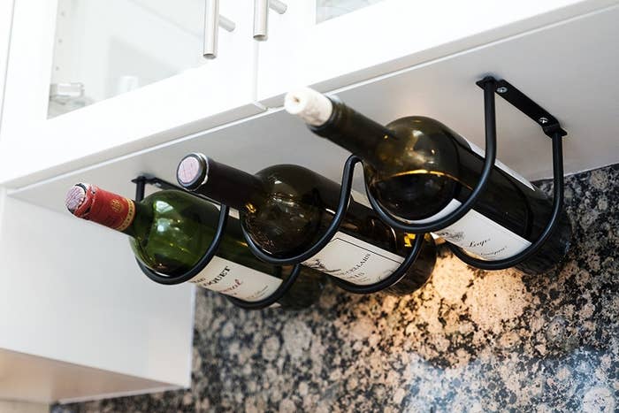 wine bottles hanging on rack attached under cabinets
