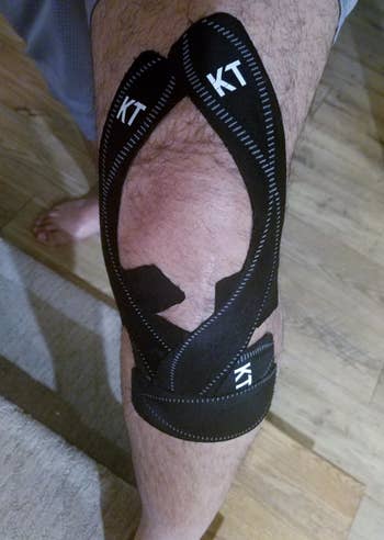 reviewer wearing the black sports tape around their knee for support