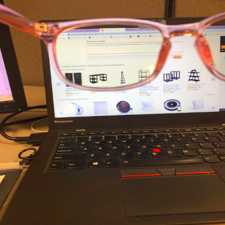 reviewer holds up glasses to show that the screen looks more orange through them 