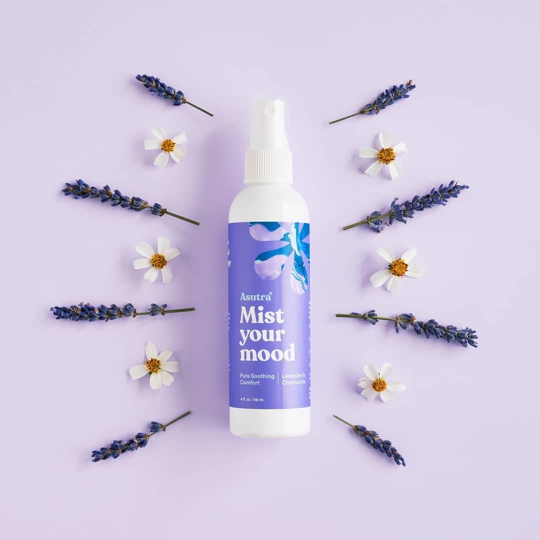 a spray bottle of the product with lavender and chamomile flowers