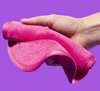 model holding pink make-removing cloth