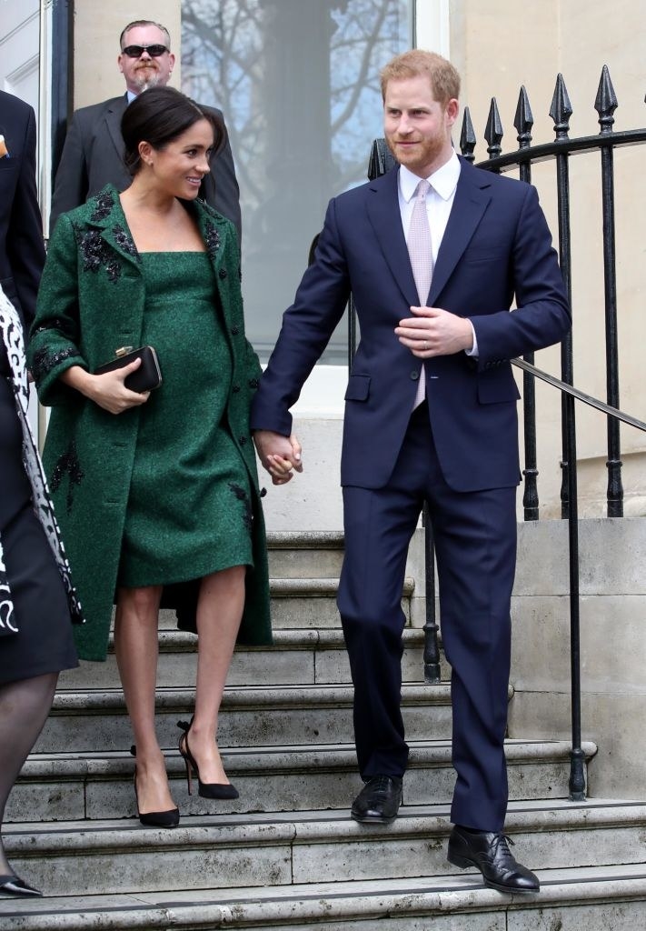 Meghan and Harry walk down stairs outside holding hands