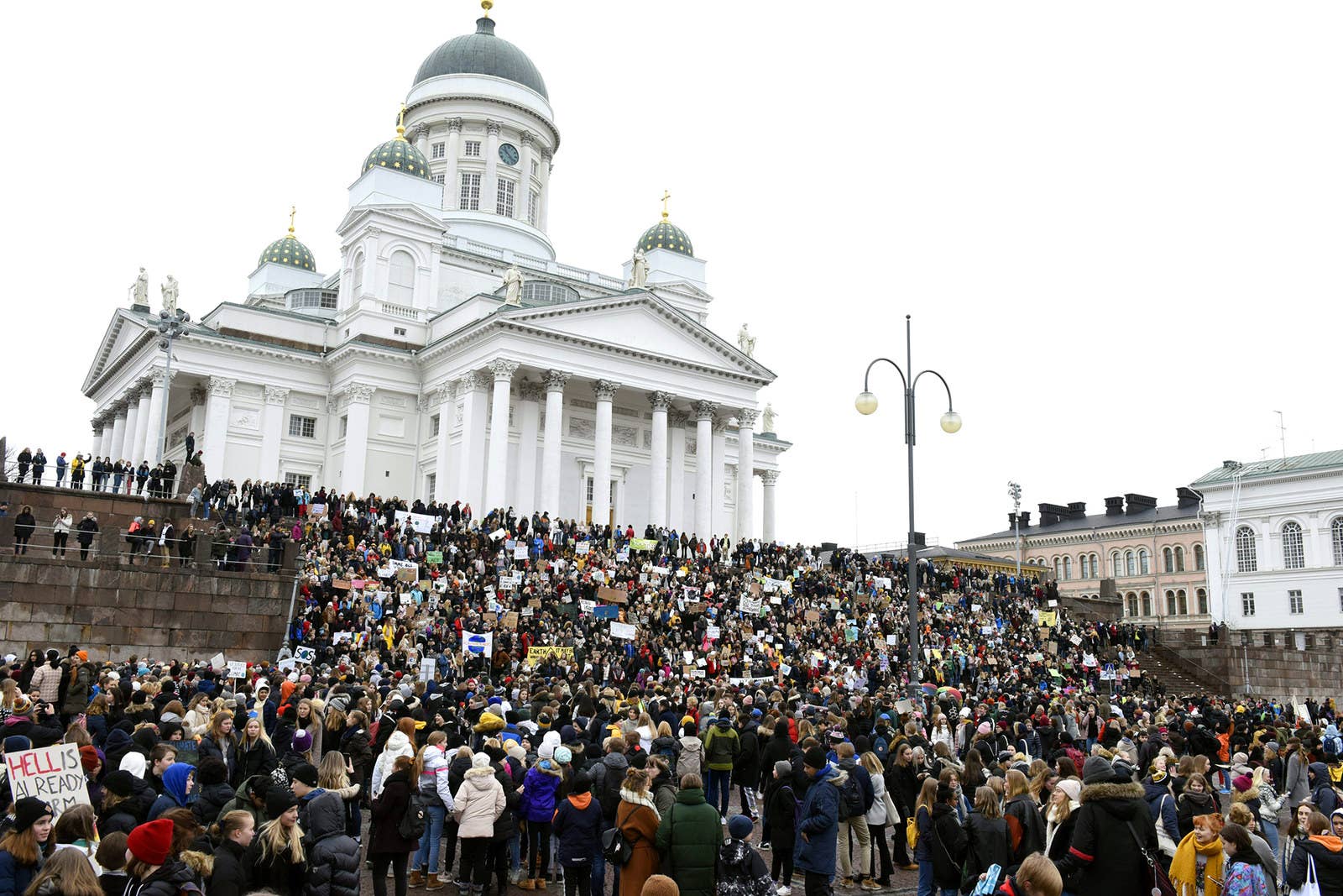 Юные демонстранты собираются на ступенях Хельсинкского собора в Хельсинки.