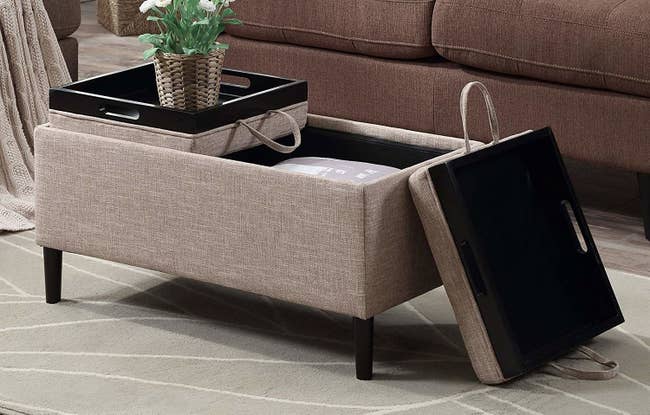 rectangular store ottoman with two pieces of lid that have serving trays on the reverse