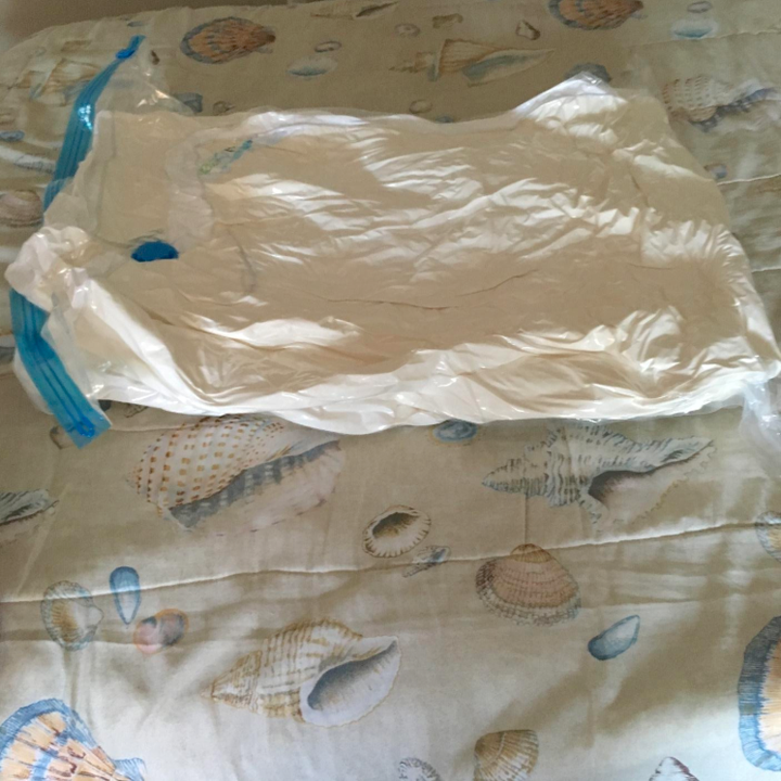 after: the same duvet in a space bag, flattened down to only an inch or so high