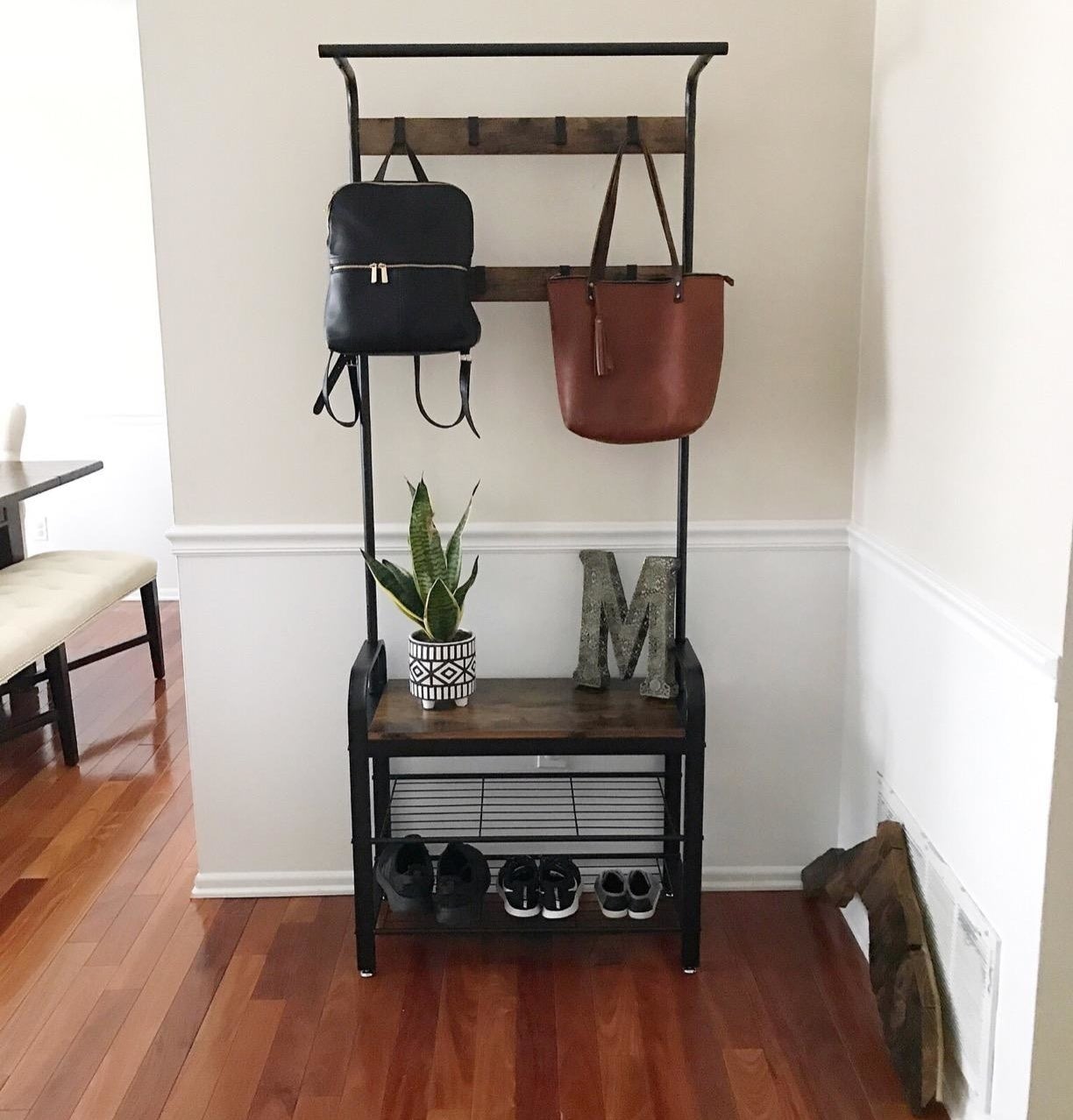 reviewer&#x27;s coat rack with bags hanging and shoes on shoe rack