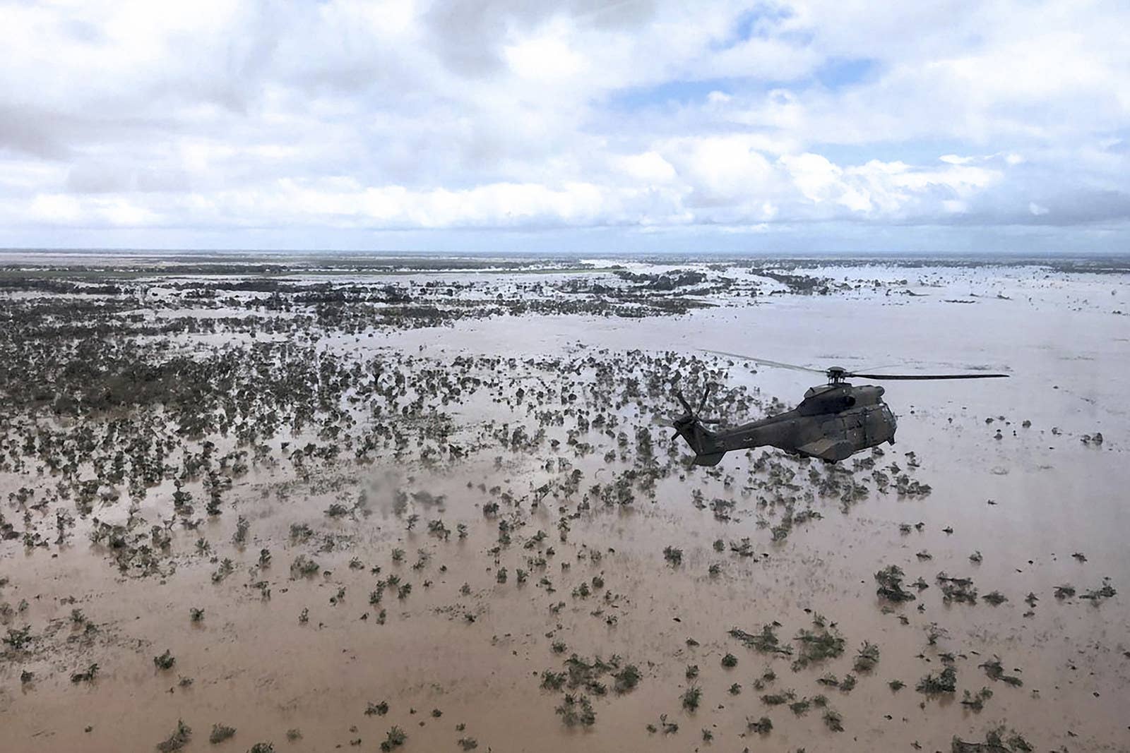 Helicóptero militar sobrevoa área alagada em Beira, no dia 20.