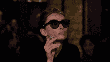 Gif of Holly from &quot;Breakfast at Tiffany&#x27;s&quot; pulling down her sunglasses to give a closer look