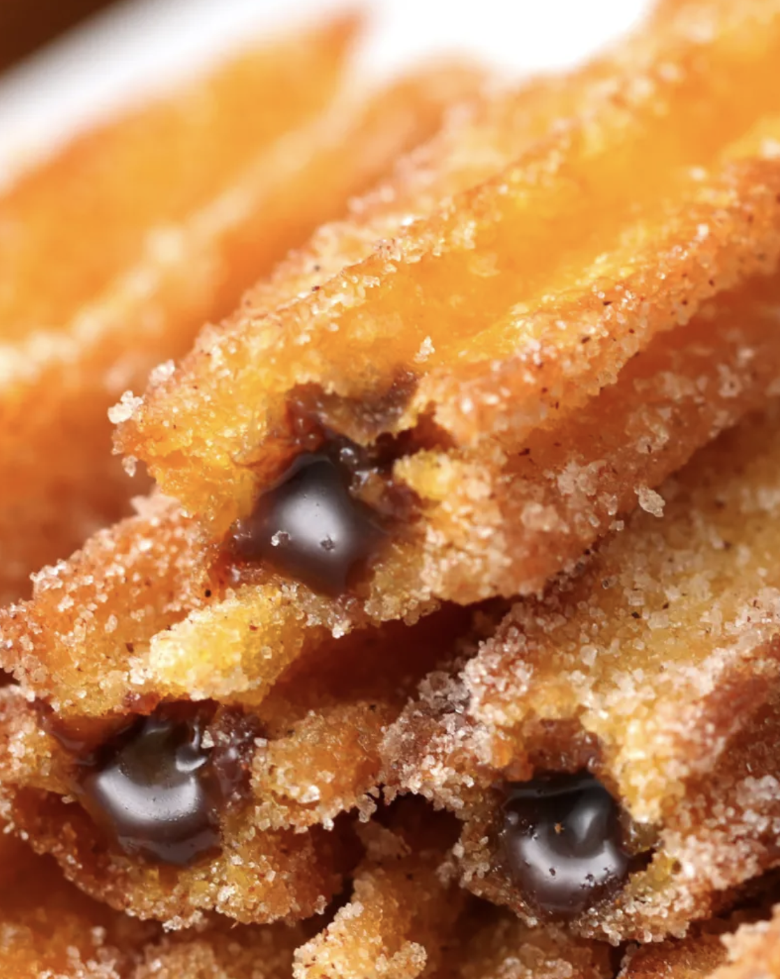 Rendimento: 20-25 churrosVocê vai precisar de:300 gramas de cenouras cortadas¼ xícara de açúcar½ xícara de manteiga derretida2 xícaras de água2 xícaras de farinha2 ovos1 lata de leite condensado3 colheres de sopa de cacau em pó2 colheres de sopa de manteigaÓleo (para fritar)Açúcar e canelaModo de preparo:1. Em um liquidificador, bata as cenouras, o açúcar, a manteiga e a água até obter uma mistura homogênea.2. Transfira o conteúdo do liquidificador para uma panela, leve ao fogo e espere ferver.3. Adicione a farinha e misture vigorosamente até obter uma massa macia.4. Retire do fogo e adicione dois ovos, um de cada vez, sempre mexendo até incorporar completamente.5. Coloque a massa em um saco de confeitar com bico de estrela. Faça algumas tiras de churros em uma assadeira e depois leve a assadeira ao congelador por 1 hora.6. Em uma panela com óleo quente em fogo médio, frite os churros até dourarem e deixe secarem em papel toalha.7. Depois, passe em açúcar e canela e com a ajuda de um canudo, fure o churros para rechear.8. Em uma panela em fogo baixo, misture o cacau em pó, a manteiga e o leite condensado. Deixe cozinhar, sem deixar de mexer, até obter o ponto de brigadeiro. O ponto é quando você passa a colher no diâmetro da panela e pode contar alguns segundos até o brigadeiro cobrir onde você passou a colher. Retire do fogo e deixe esfriar.9. Coloque o brigadeiro em um saco de confeitar ou um saco tipo ziploc cortado na ponta e recheie os churros. Sirva!