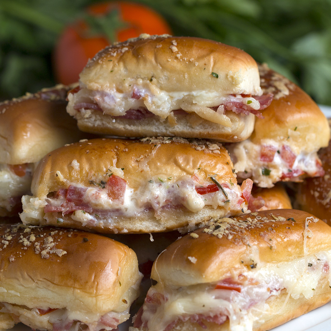 Você vai precisar de:12 bisnaguinhas200g de salame fatiado200g de queijo muçarela2 tomates picados½ xícara de requeijão2 colheres de sopa de manteiga derretida2 colheres de sopa de queijo parmesão ralado1 colher de sopa de salsinhaModo de preparo:1. Preaqueça o forno a 180°C.2. Corte as bisnaguinhas na metade e reserve.3. Coloque as bases das bisnaguinhas no fundo de uma travessa.4. Coloque o salame, seguido pela muçarela, o tomates e cubra com o topo das bisnaguinhas.5. Espalhe a manteiga derretida, o parmesão e a salsinha.6. Leve ao forno por 10-15 minutos ou até ficar dourado.7. Sirva em seguida.