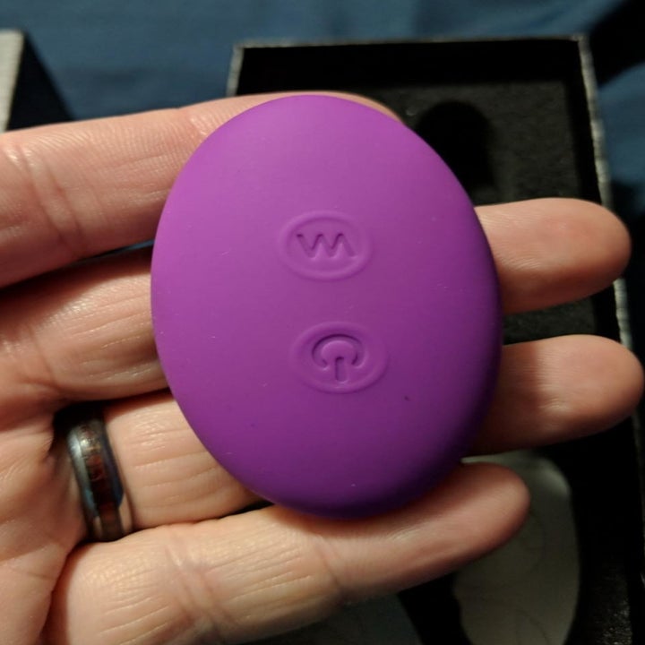 A review photo of a hand holding the G spot vibrator remote with two control buttons