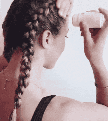 A gif of a model applying the stick to tame down flyaways