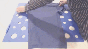 GIF of person using the board to fold a shirt