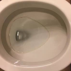 a toilet bowl with a stained ring inside