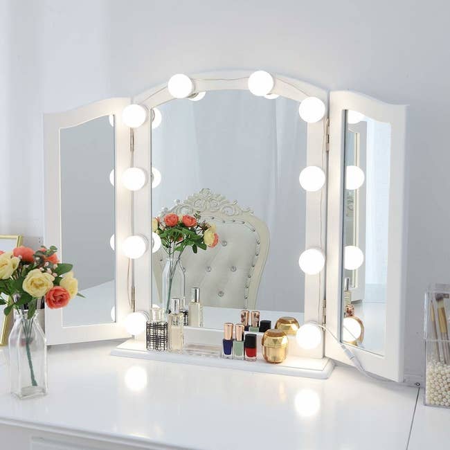 a vanity mirror surrounded by bulb lights