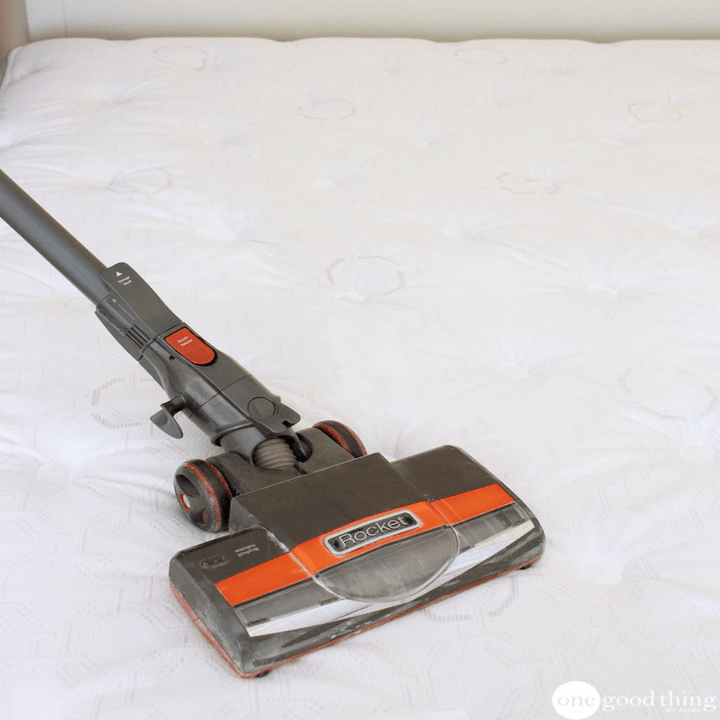 Blogger vacuuming a mattress