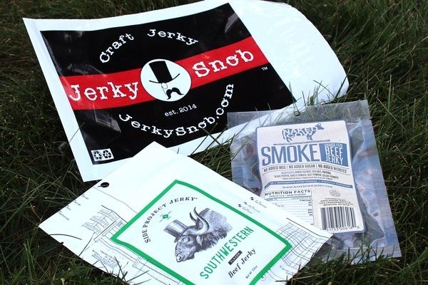 three bags of jerky outside in the grass