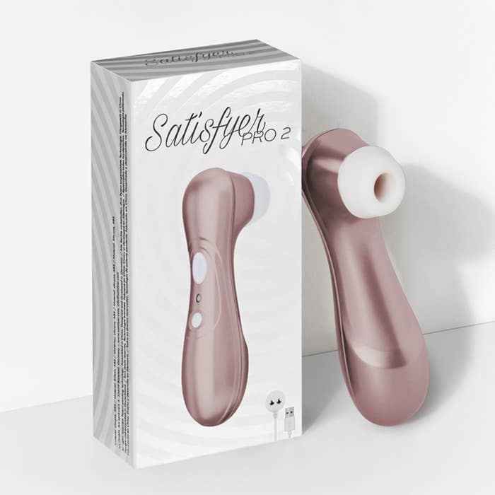 the pink satisfyer suction toy leaving against its box