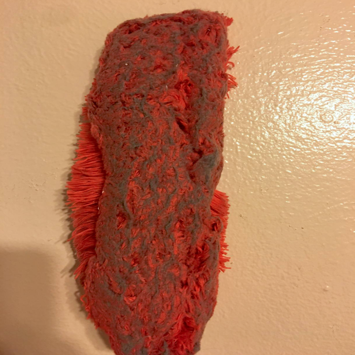 A reviewer's orange duster head covered with all the dirt it picked up