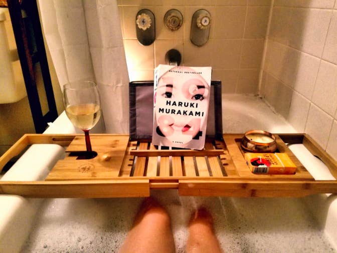 a reviewer in the tub with the bath tray over their legs