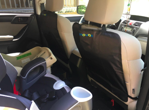 inside of a mini van with seat protectors on the back of the two front seats