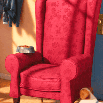 Animated Gif of Max from the movie &quot;The Secret Life of Pets&quot; tossing a pillow on an armchair, turning in circles, and laying down with a contented sigh