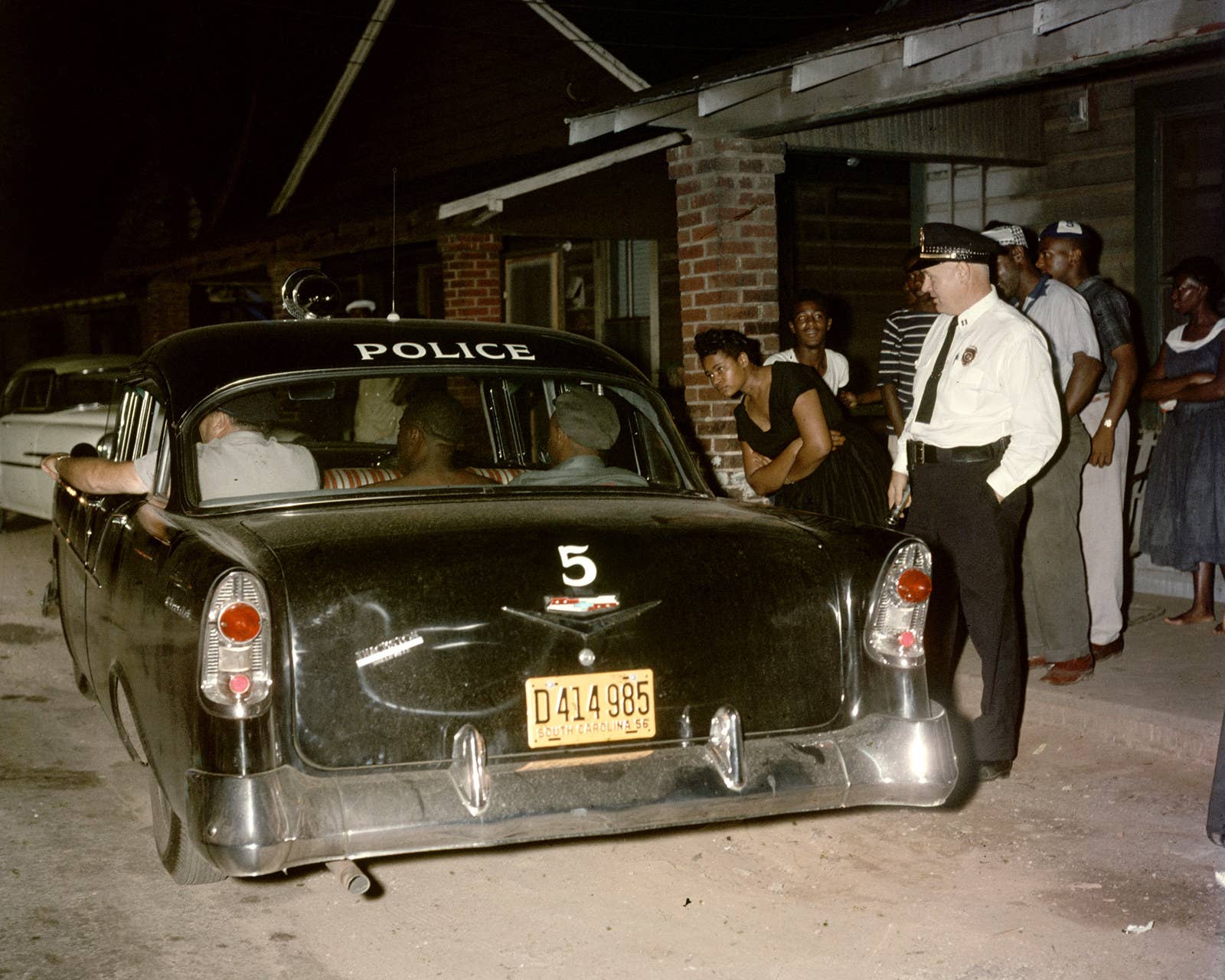 Pessoas observam um homem sendo preso por desordem em Greenville, Carolina do Sul, 1956.
