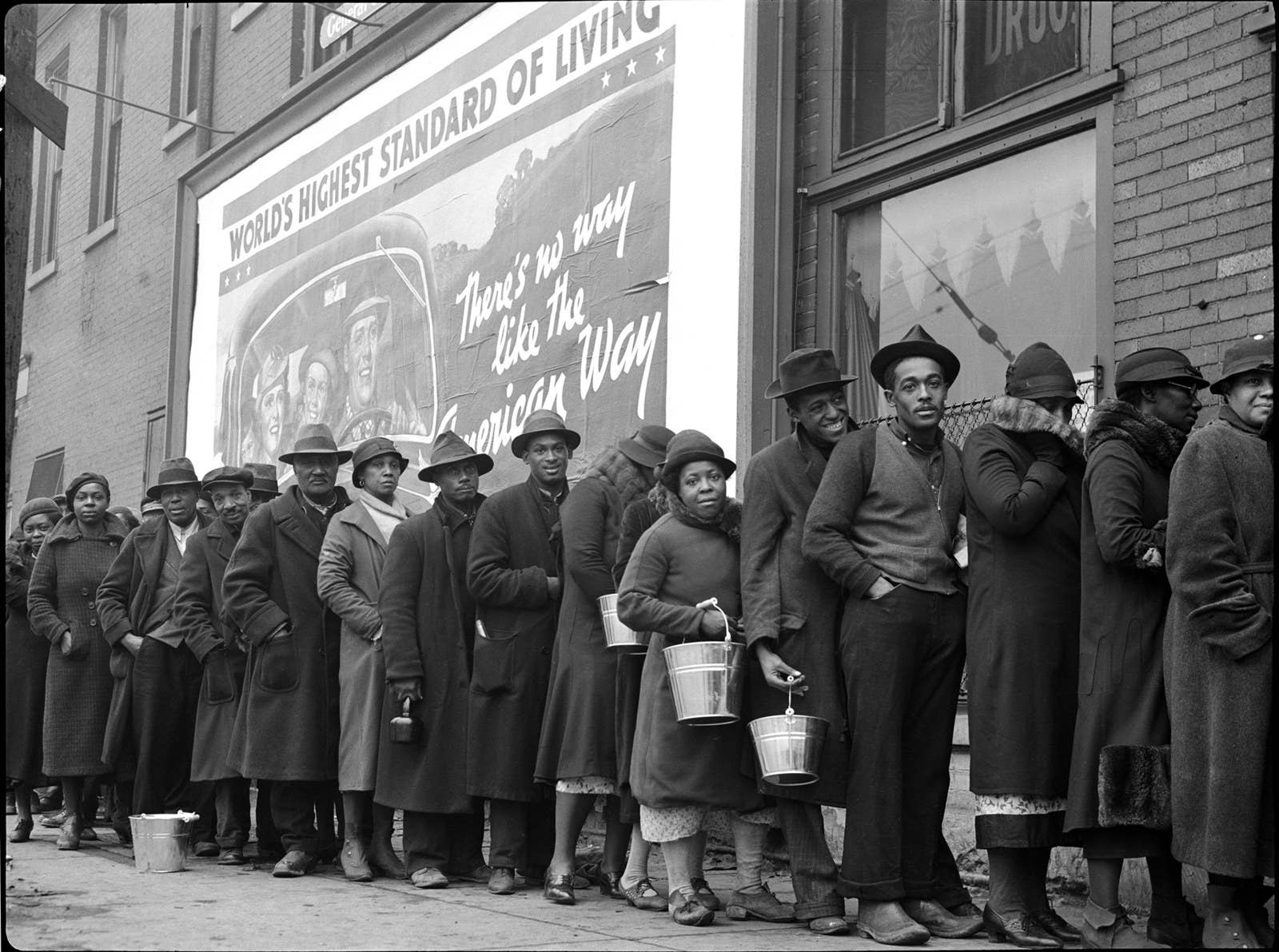 Negros vítimas de enchentes fazem fila para pegar comida e roupas em uma estação da Cruz Vermelha em fevereiro de 1937.