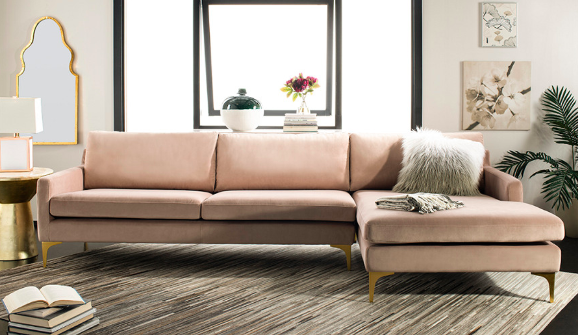 The baby pink sofa on display with furnishings behind it