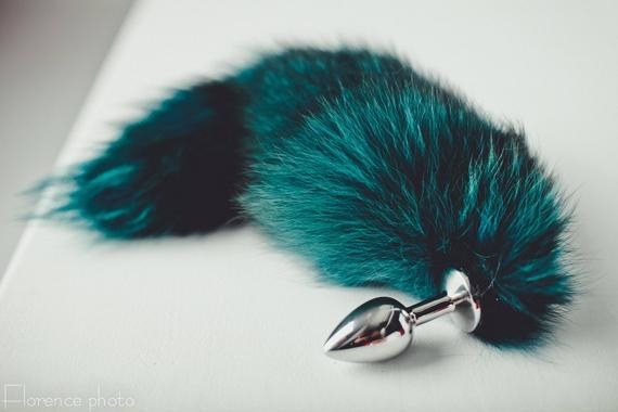 a turquoise-colored tail attached to a metal plug 